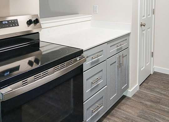 A modern kitchen with a stove top oven and a counter top.