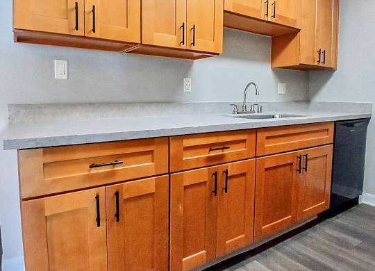 A kitchen with wooden cabinets and a sink.