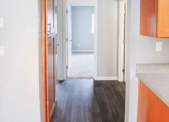 A hallway with wood floors and white walls.