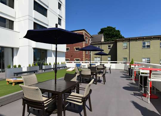 A patio with a table and chairs is surrounded by buildings.