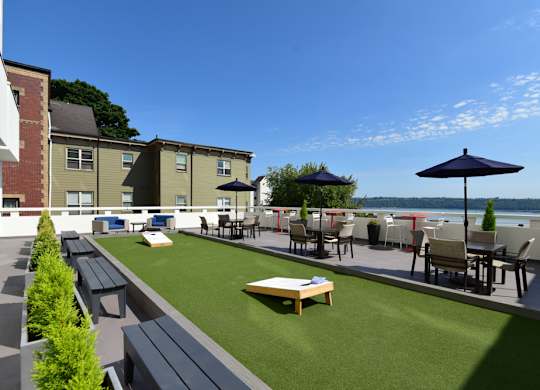 A patio area with a table and chairs overlooking a body of water.
