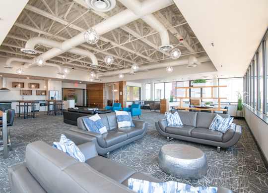 A spacious room with grey couches and a patterned carpet