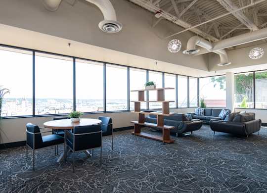 A conference room with a table, chairs, and a view of the city.