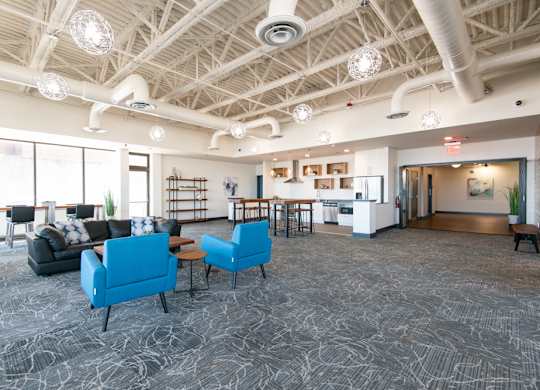 A spacious room with a patterned carpet and a variety of seating options.