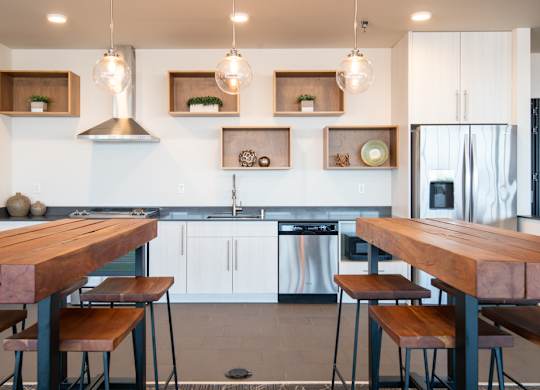 A modern kitchen with a wooden table and stools.