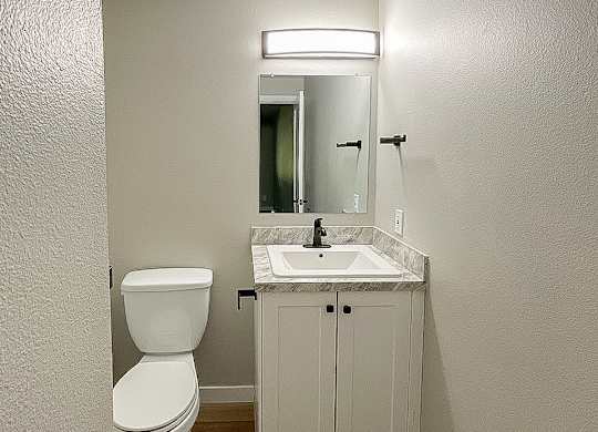 A white toilet sits next to a sink in a small bathroom.