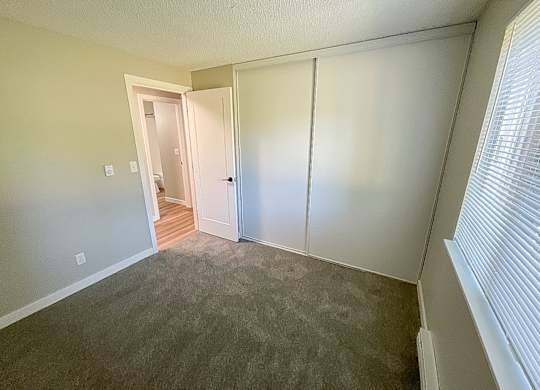 A room with a carpeted floor and a white door.