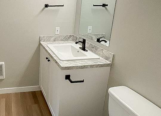 A white toilet sits next to a sink in a small bathroom.