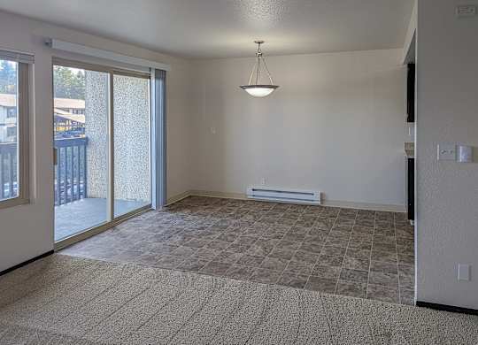 A room with a carpeted floor and a hanging light fixture.