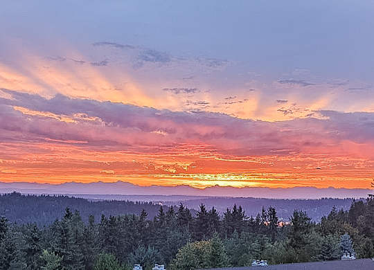 A beautiful sunset with vibrant colors and rays of light shining through the clouds.