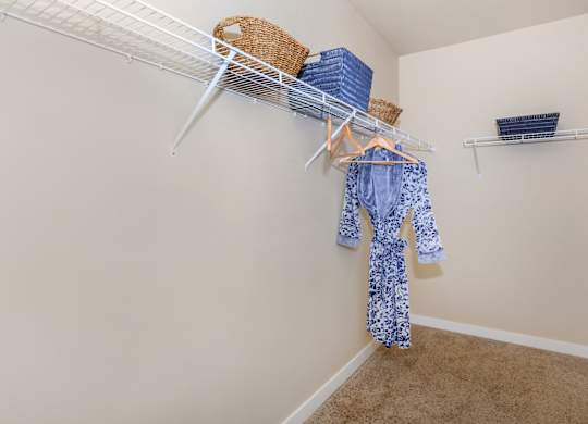 A baby onesie is hanging on a clothesline in a room.