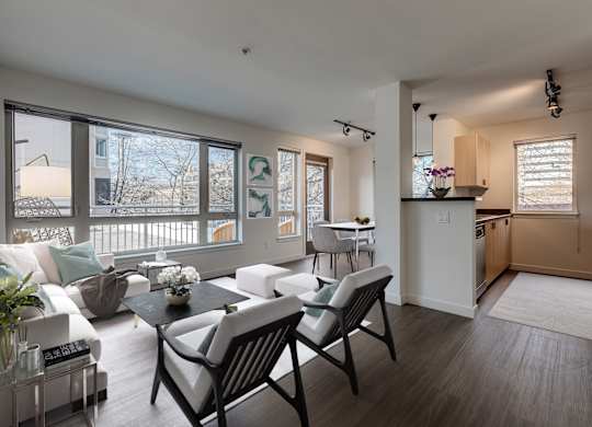 A modern living room with a dining area and kitchen in the background.