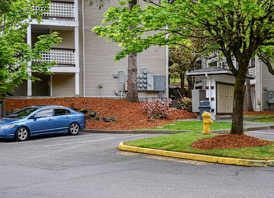A blue car is parked in front of a building.
