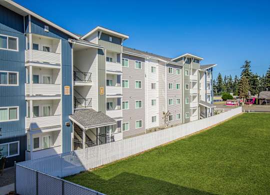 Apartment complex with a green lawn in front.