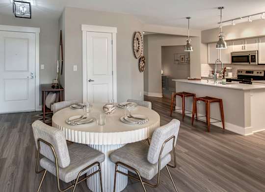 A dining room with a round table and chairs.