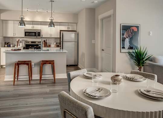 A modern kitchen with a dining table set for two.