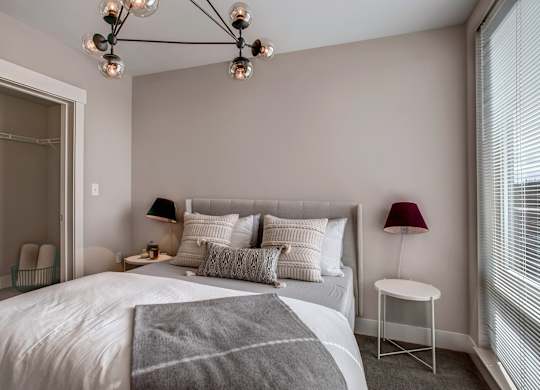 A bedroom with a large bed and a chandelier.