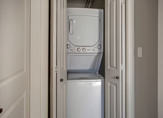 A white dishwasher is in a narrow space between two doors.
