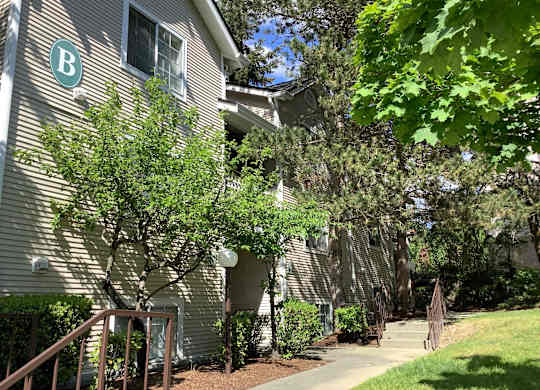 A building with a B on it is surrounded by trees.