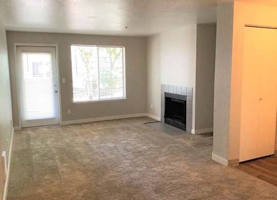 A living room with a fireplace and a carpeted floor.