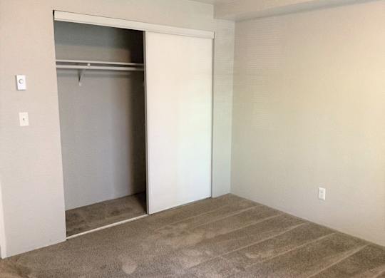 A room with a white door and a carpeted floor.
