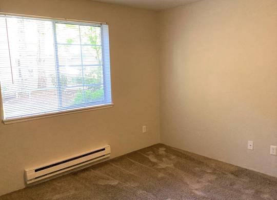 A room with a window and a wall-mounted air conditioner.