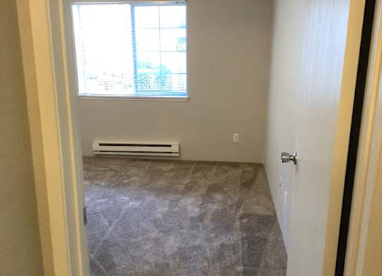 A room with a window and a tiled floor.