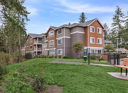 A large apartment complex with a grassy area in front.