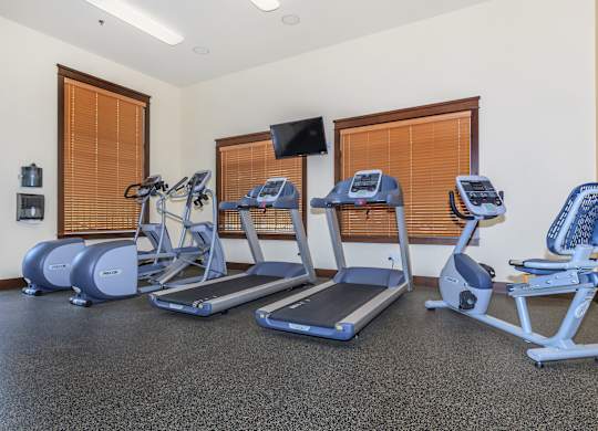 A gym with treadmills, elliptical machines, and exercise bikes.