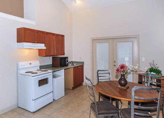 A kitchen with a white stove and brown cabinets.