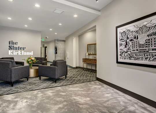 A waiting area with chairs and a large artwork on the wall.