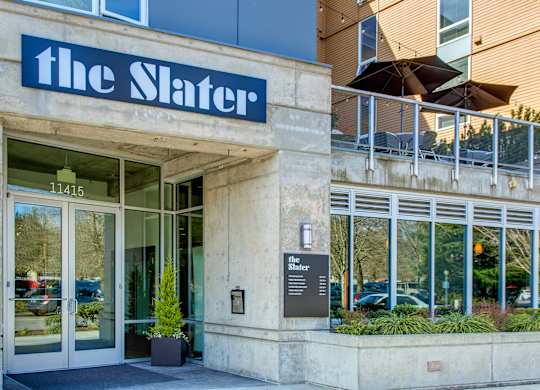 The Slater building has a glass door and a plant in front of it.