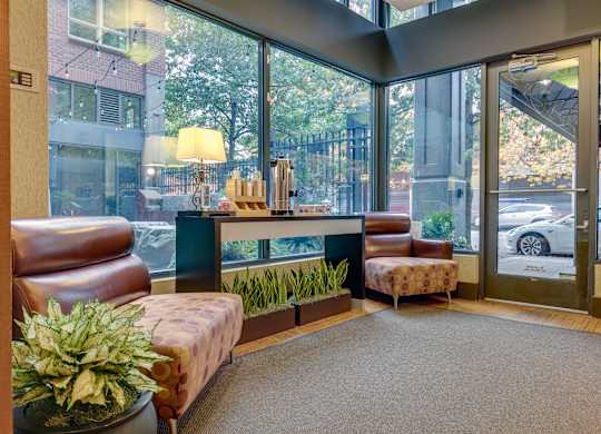A waiting area with a couch, chair, and potted plant.