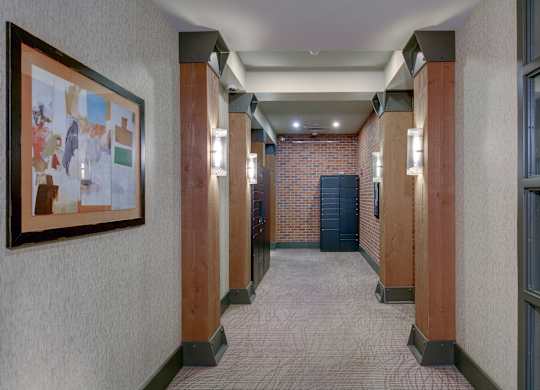 A hallway with a brick wall and a framed picture on the wall.