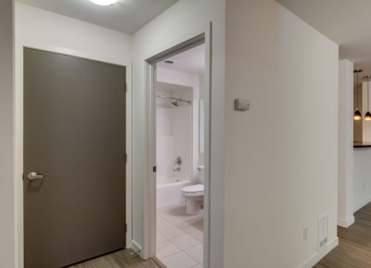 A bathroom with a toilet and sink is visible through an open door.