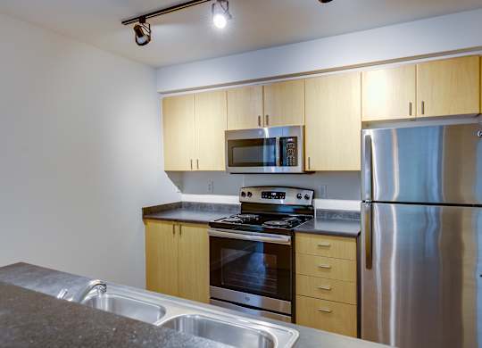 A kitchen with a stove top oven, microwave, and refrigerator.