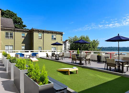 A patio with a table and chairs overlooking a body of water.