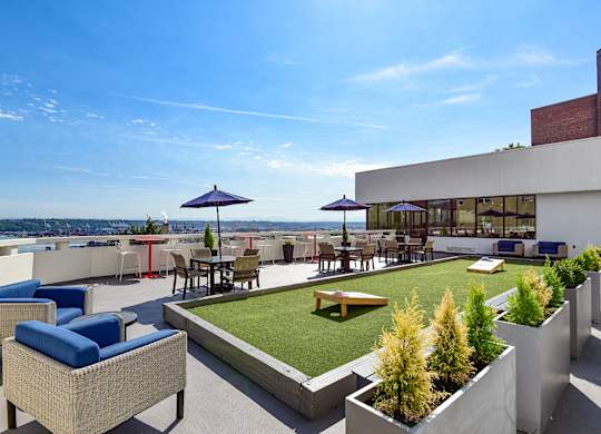 A rooftop patio with a table and chairs overlooking the water.