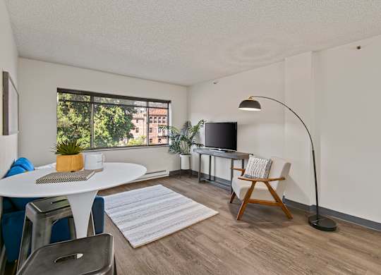 A living room with a white table and a television.