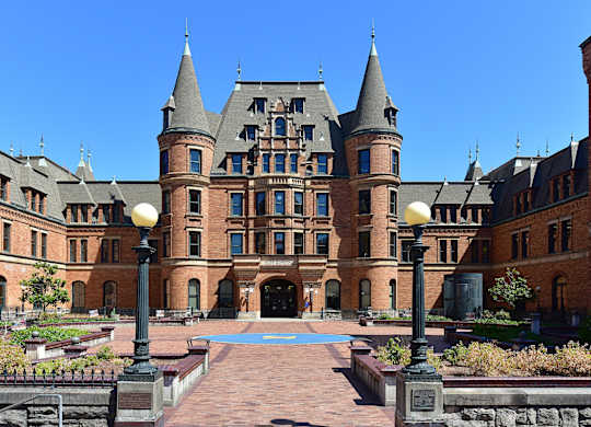 A large castle-like building with a courtyard in front.