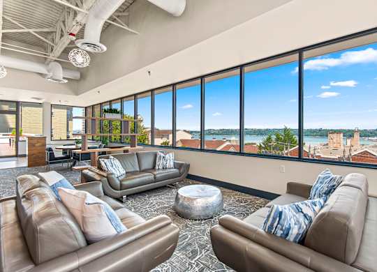 A living room with two couches and a large window overlooking a cityscape.