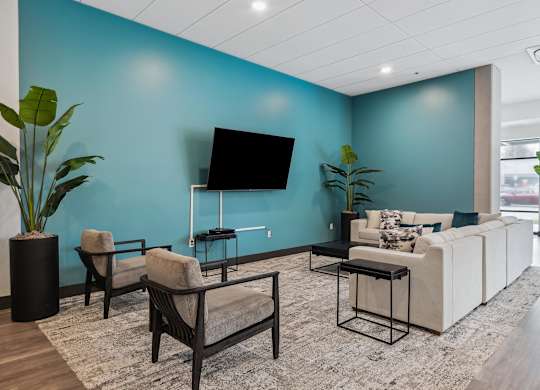 A Lounge space with a blue wall and a flat screen TV.