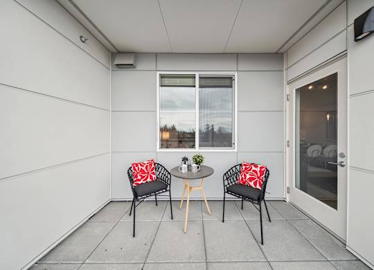 A small table with two chairs and a vase on it.