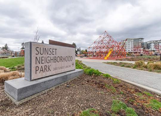 A sign for Sunset Neighborhood Park is in front of a construction site.