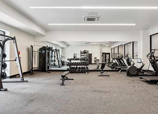 A spacious gym with a variety of equipment including treadmills, weights, and exercise machines.