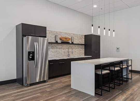 A modern kitchen with a stainless steel refrigerator and a white countertop.