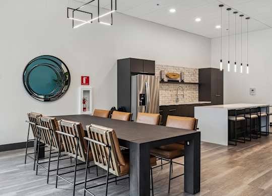 A modern dining room with a long table and chairs.