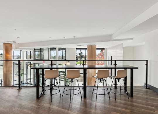 A modern dining room with a glass table and chairs.