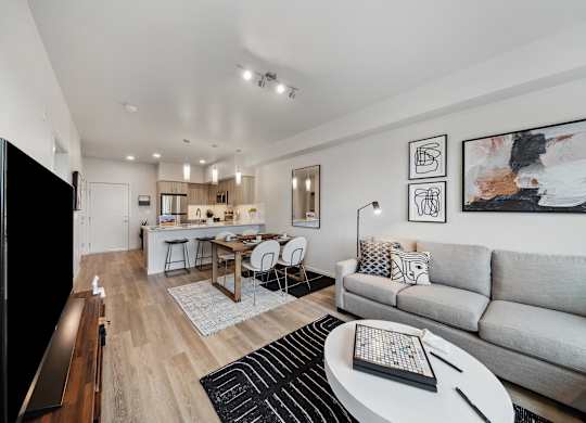 A modern living room with a grey couch, a wooden coffee table, and a flat screen TV.
