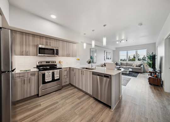 A modern kitchen with wooden cabinets and a stainless steel refrigerator.